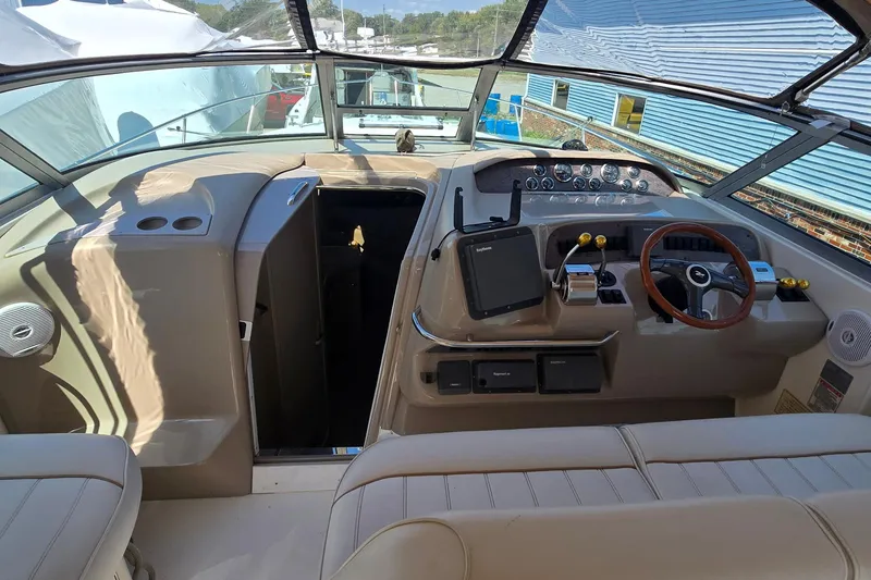 Slide: The Image of 1998 Sea Ray 330 Sundancer cockpit with steering wheel, control panel, and navigation equipment. - 7