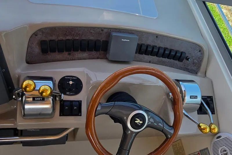 Slide: The Image of 1998 Sea Ray 330 Sundancer helm with wooden steering wheel and control panel. - 8