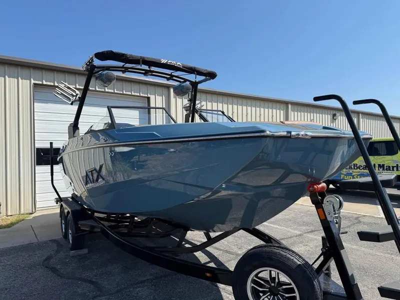 Slide: The Image of 2026 ATX Surf Boats 22 Type-S on trailer, parked outside a warehouse. - 3