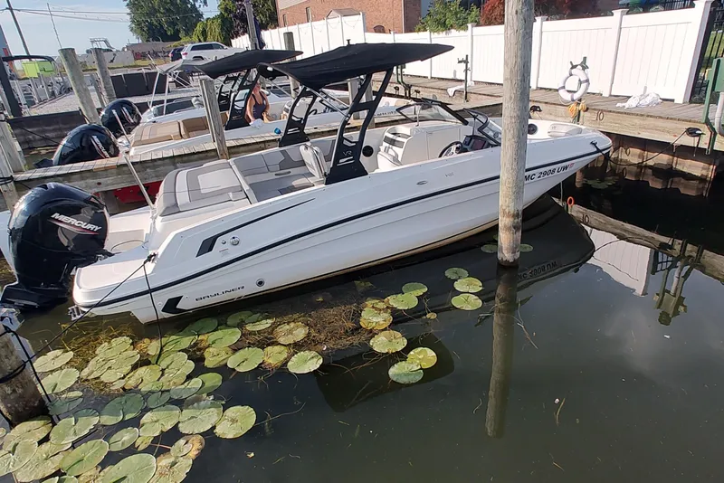 The Image of 2023 Bayliner VR6 Bowrider OB docked, featuring sleek design and Mercury outboard engine. - 0