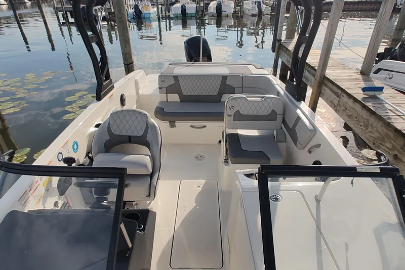 Slide: The Image of 2023 Bayliner VR6 Bowrider OB interior with seating, docked at marina. - 11