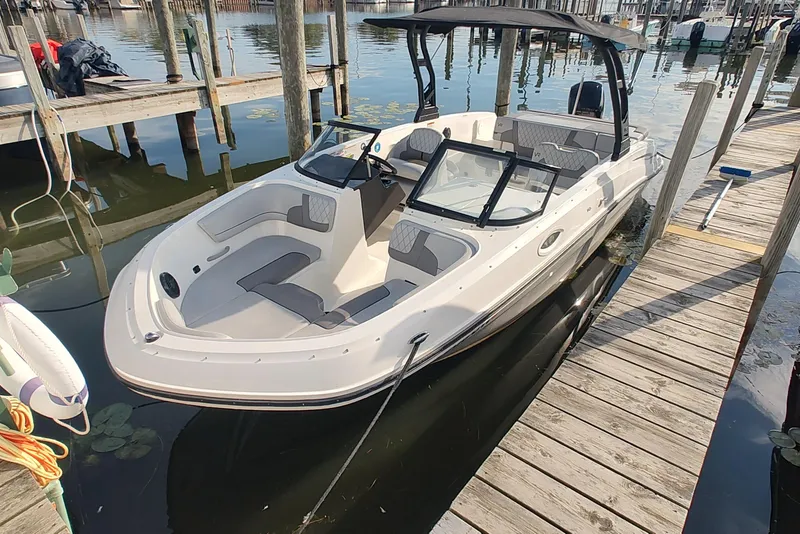 Slide: The Image of 2023 Bayliner VR6 Bowrider OB docked at a marina, featuring spacious seating and sleek design. - 4