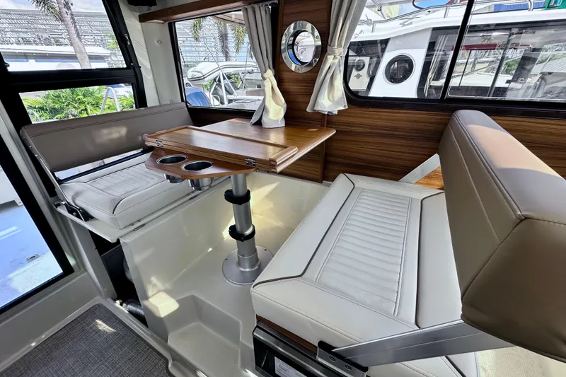 Slide: The Image of Interior of 2026 Ranger Tugs R-25 with seating and wooden table. - 10