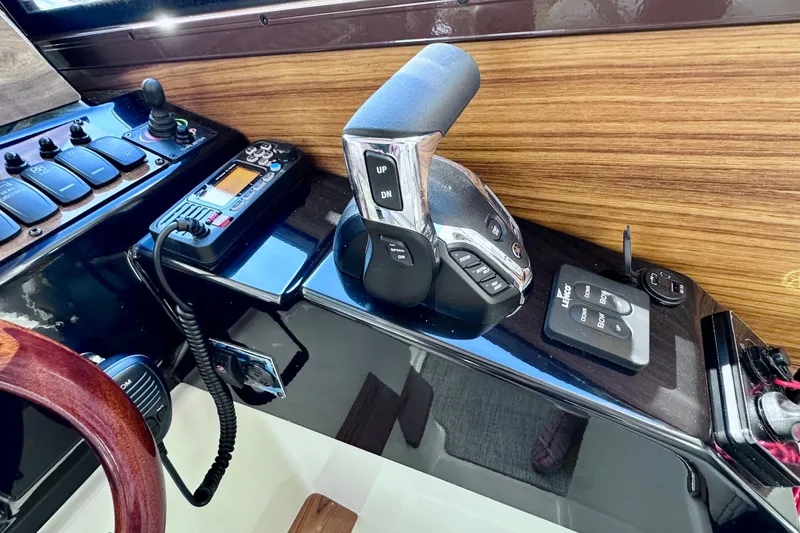 Slide: The Image of 2026 Ranger Tugs R-25 helm controls with modern navigation equipment and wood accents. - 15