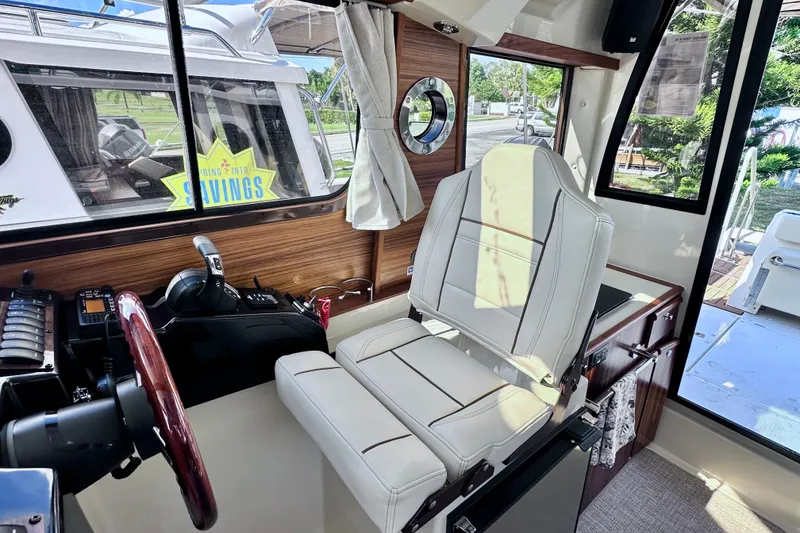 Slide: The Image of Interior of 2026 Ranger Tugs R-25 boat with helm and seating area. - 17