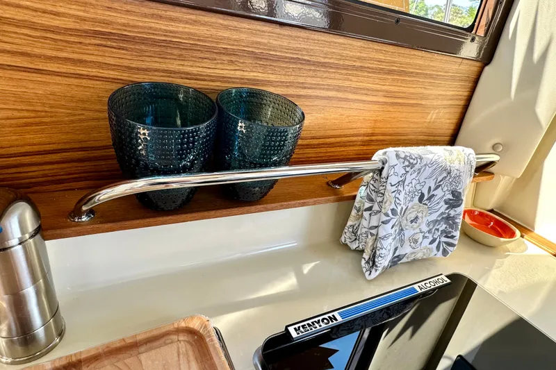 Slide: The Image of Interior of 2026 Ranger Tugs R-25 with glasses, towel, and stove. - 21