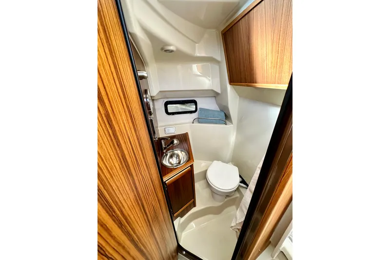 Slide: The Image of 2026 Ranger Tugs R-25 boat bathroom with wood accents and compact design. - 29