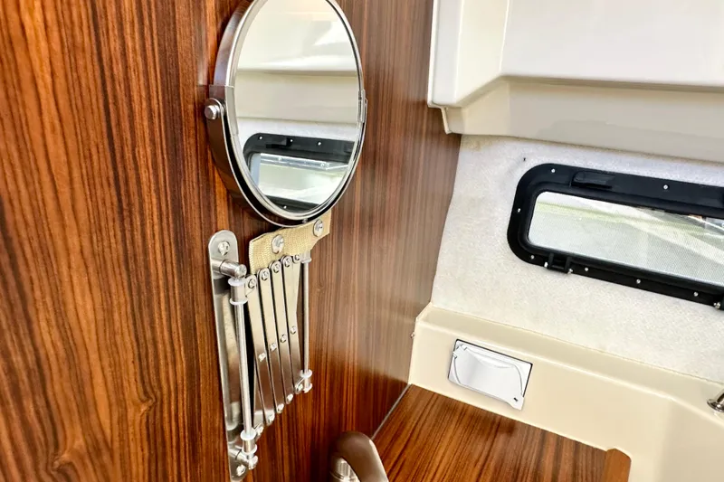 Slide: The Image of Interior of 2026 Ranger Tugs R-25 boat with wood paneling and round mirror. - 34