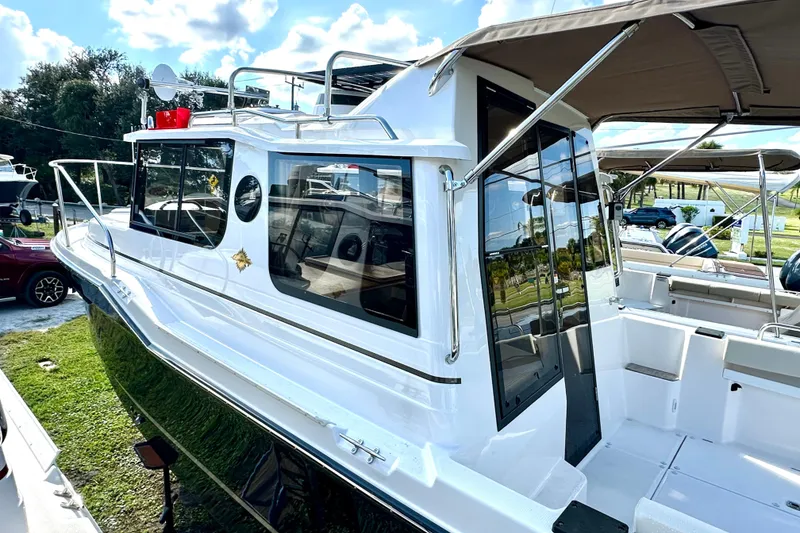 Slide: The Image of 2026 Ranger Tugs R-25 boat with sleek design, docked outdoors under a sunny sky. - 4