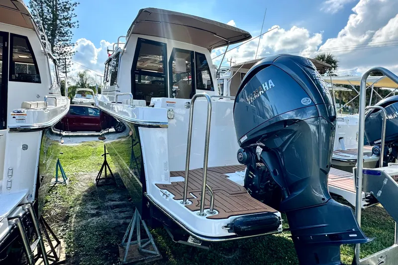 Slide: The Image of 2026 Ranger Tugs R-25 boat with Yamaha outboard motor, docked under a sunny sky. - 5