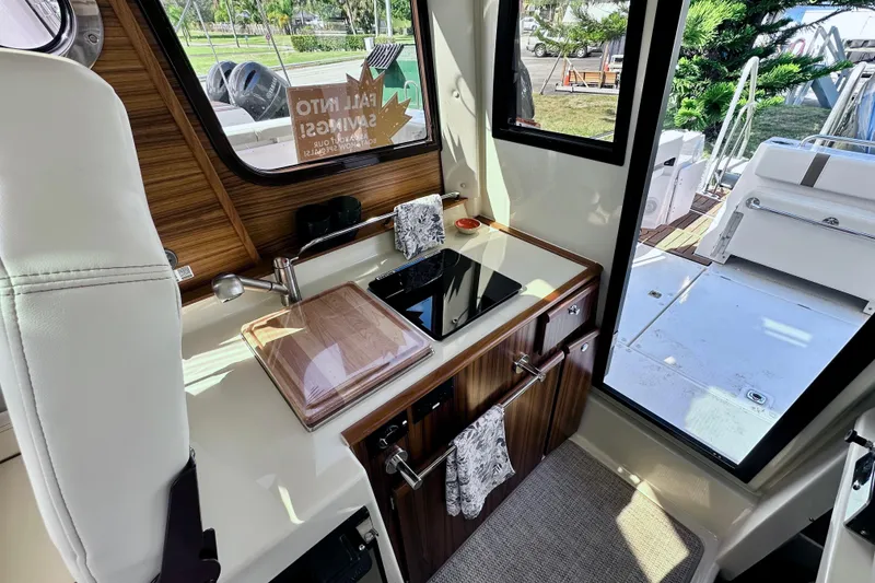 Slide: The Image of 2026 Ranger Tugs R-25 interior kitchen with modern amenities and sleek design. - 8