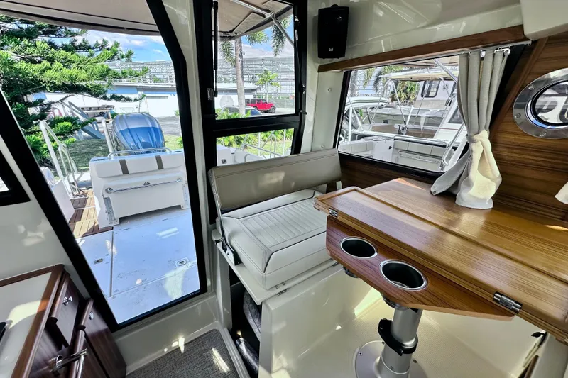 Slide: The Image of Interior of 2026 Ranger Tugs R-25 boat with seating and wooden table. - 9