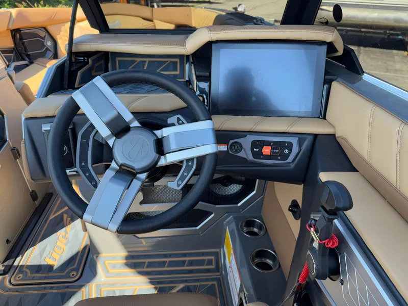 Slide: The Image of 2025 Tigé Ultré 25ZX boat interior with modern steering wheel and touchscreen display. - 10
