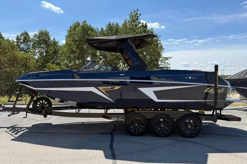 Slide: The Image of 2026 Tigé 24RZX boat on trailer, sleek design, parked outdoors under clear sky. - 4
