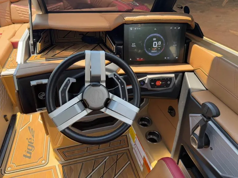 Slide: The Image of 2024 Tigé Ultré 25ZX boat dashboard with modern steering wheel and touchscreen display. - 11