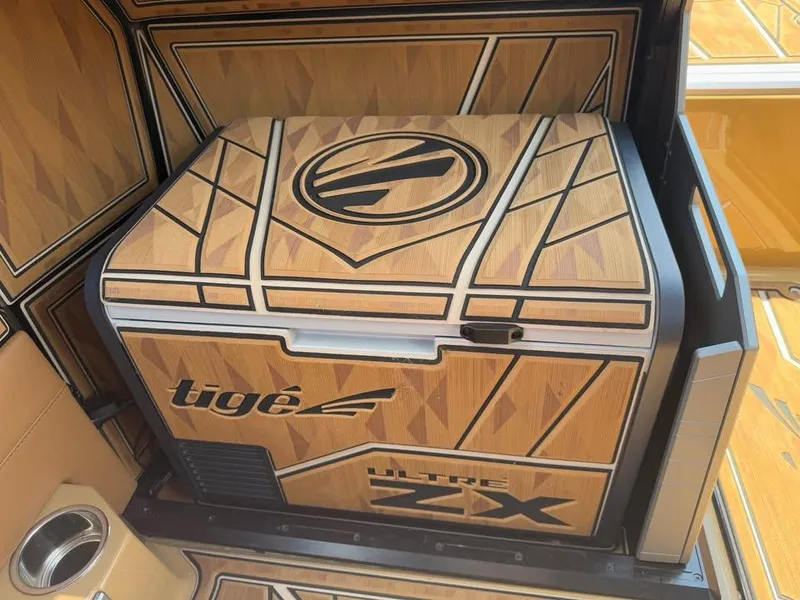 Slide: The Image of 2024 Tigé Ultré 25ZX boat interior with stylish wood paneling and logo detailing. - 14