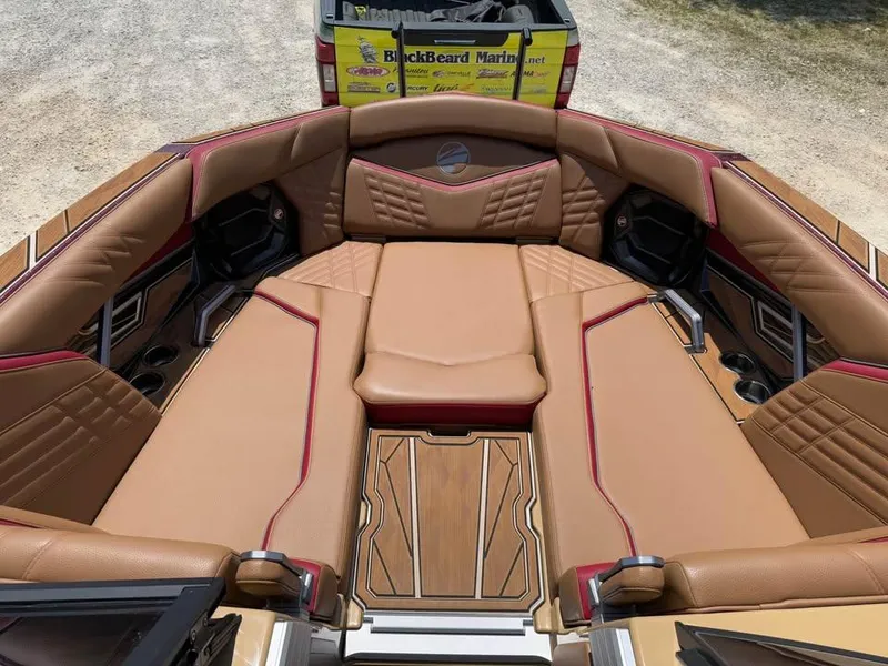 Slide: The Image of 2024 Tigé Ultré 25ZX boat interior with luxurious tan and red seating. - 15