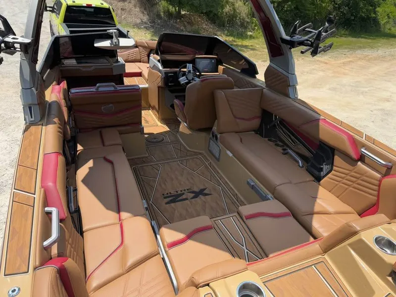 Slide: The Image of 2024 Tigé Ultré 25ZX boat interior with luxurious tan and red seating, advanced dashboard. - 8