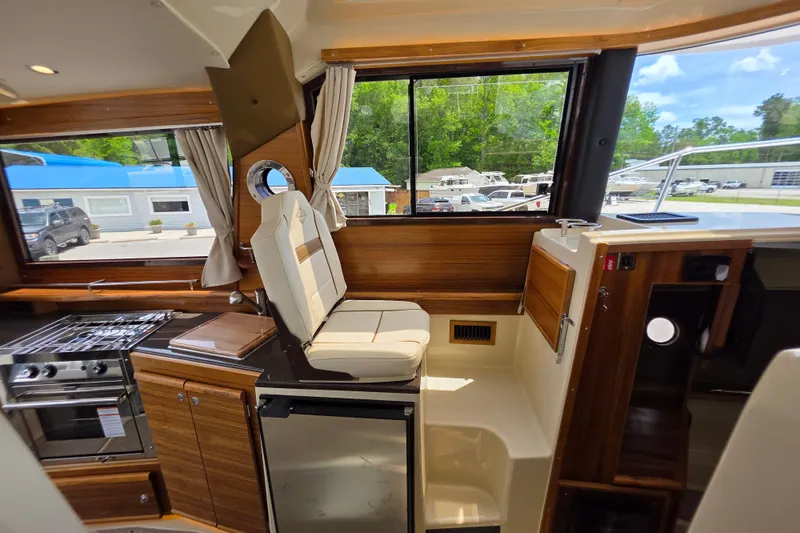 Slide: The Image of Interior of 2026 Ranger Tugs R-29 CB with modern kitchen and seating area. - 13