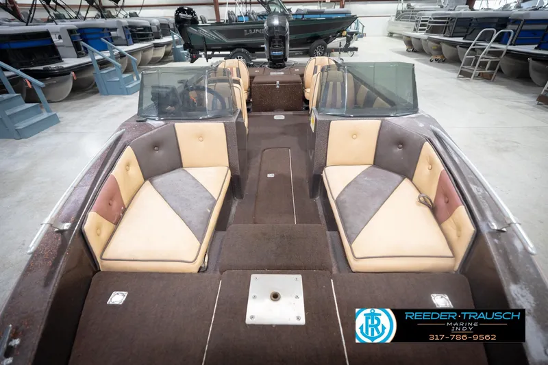 Slide: The Image of 1986 ProCraft 1775 Bass boat interior with dual seating and windshield in a showroom. - 18