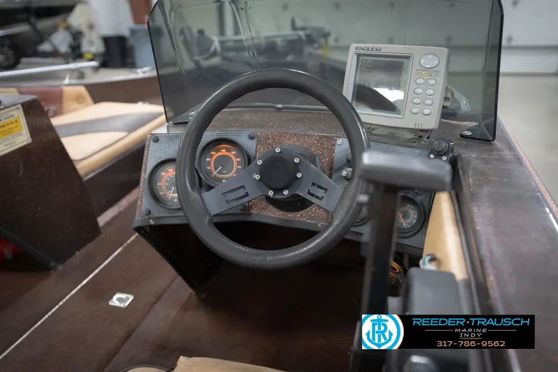 Slide: The Image of 1986 ProCraft 1775 Bass boat dashboard with steering wheel and gauges. - 34
