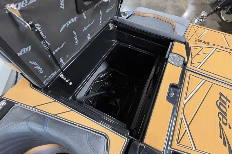 Slide: The Image of 2026 Tigé Ultré 25ZX boat storage compartment with open lid, showcasing interior details. - 26
