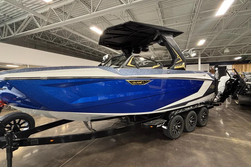 Slide: The Image of 2026 Tigé Ultré 25ZX boat in showroom, featuring sleek blue and white design. - 34