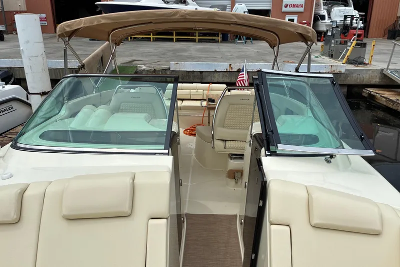 Slide: The Image of 2022 Chris-Craft Launch 35 GT boat with beige seating and canopy at a dock. - 21