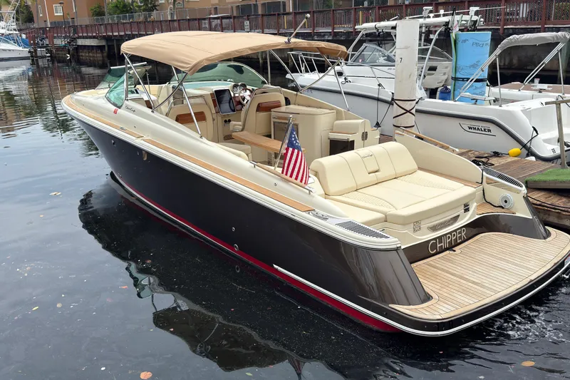 Slide: The Image of 2022 Chris-Craft Launch 35 GT boat docked, featuring elegant design and American flag. - 3