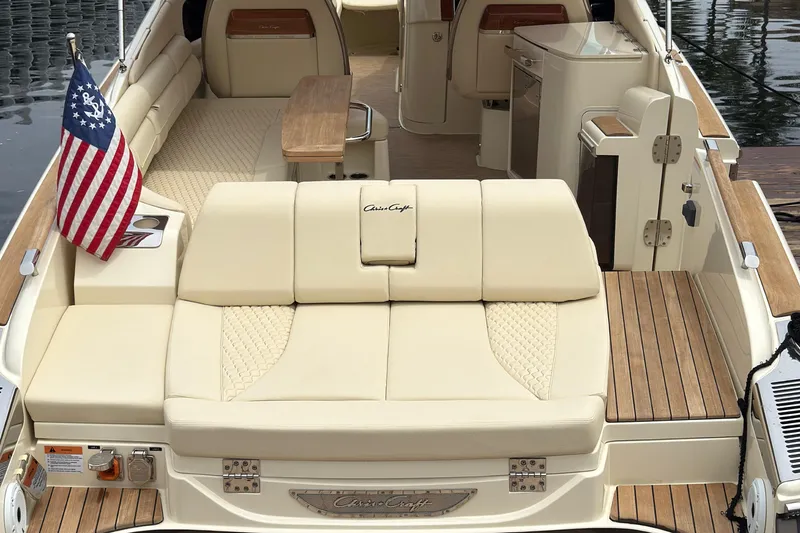 Slide: The Image of 2022 Chris-Craft Launch 35 GT luxury boat interior with beige seating and American flag. - 7