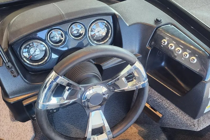 Slide: The Image of Steering wheel and dashboard of a 2023 Lowe boat with gauges and controls. - 13