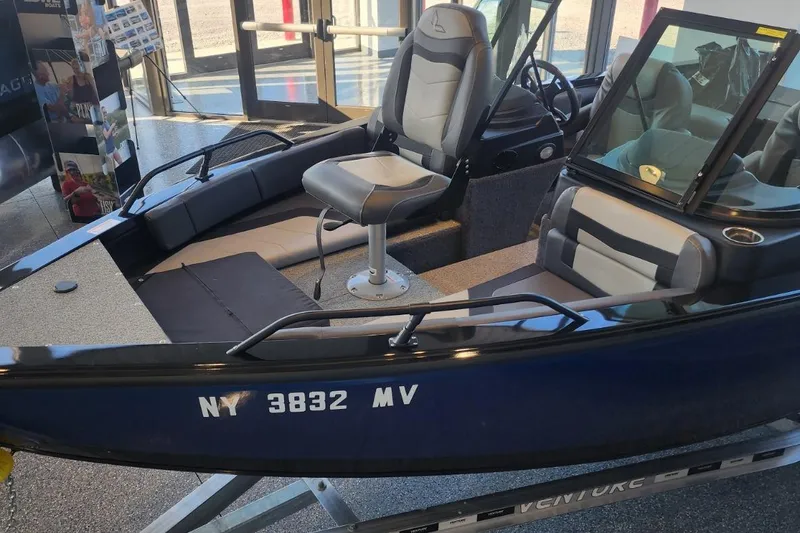 Slide: The Image of 2023 Lowe boat interior with seating and windshield, displayed indoors. - 7