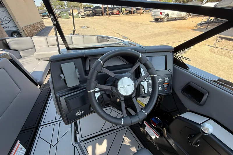 Slide: The Image of 2024 Moomba Tykon boat dashboard with steering wheel and control panel. - 11