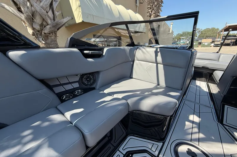 Slide: The Image of 2024 Moomba Tykon boat interior with gray seating and cup holders. - 9