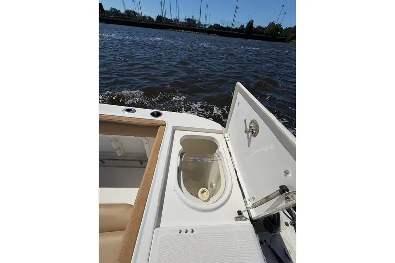 Slide: The Image of 2007 Triton 351 Express boat with open storage compartment on a sunny day. - 17