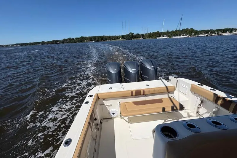 Slide: The Image of 2007 Triton 351 Express boat cruising on a sunny day with triple engines. - 18
