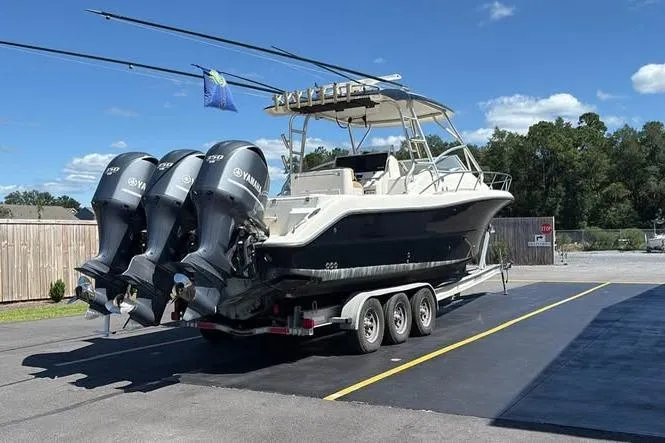 Slide: The Image of 2007 Triton 351 Express boat on trailer with triple Yamaha outboard engines. - 4