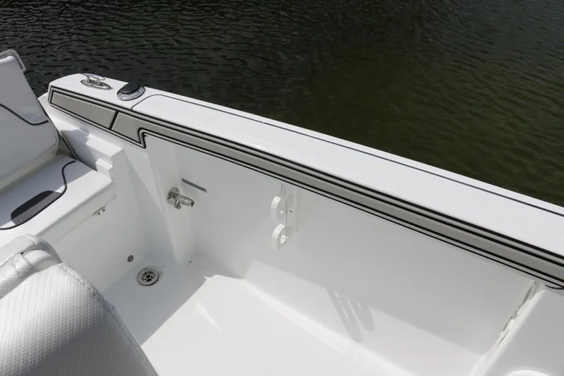 Slide: The Image of 2026 Wellcraft 202 Fisherman boat interior detail with white seating and water backdrop. - 20