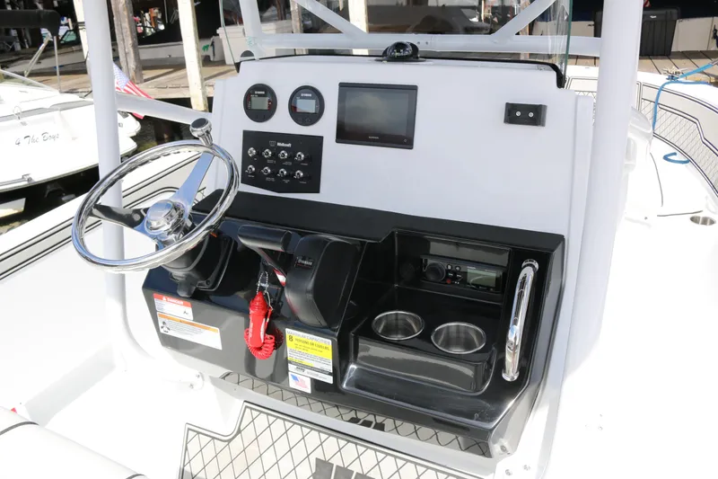 Slide: The Image of 2026 Wellcraft 202 Fisherman boat console with steering wheel, gauges, and cup holders. - 24
