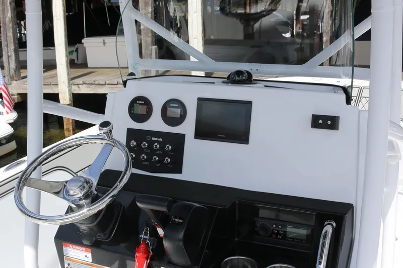 Slide: The Image of 2026 Wellcraft 202 Fisherman boat dashboard with steering wheel and control panel. - 25
