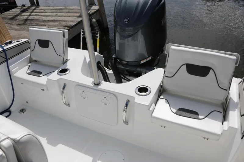 Slide: The Image of 2026 Wellcraft 202 Fisherman boat interior with seating and motor, docked by water. - 29