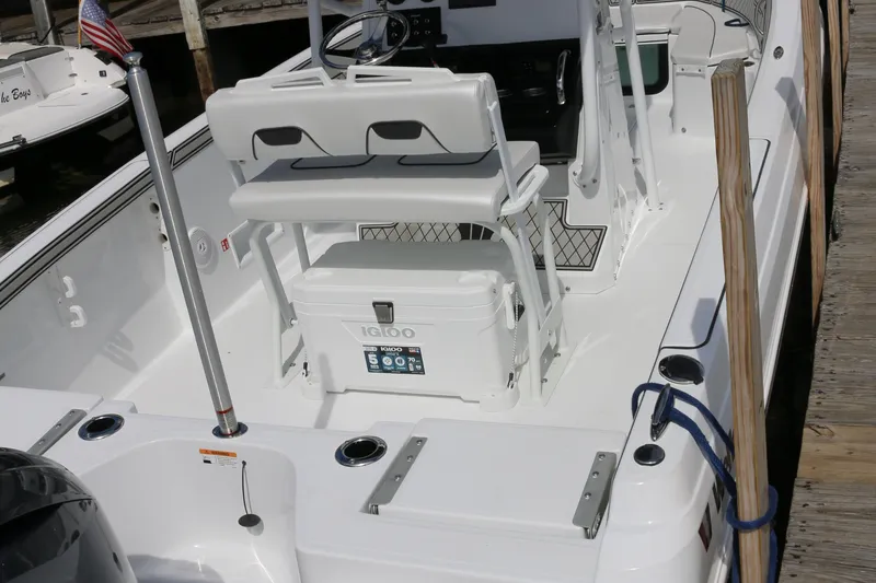 Slide: The Image of 2026 Wellcraft 202 Fisherman boat interior with seating and cooler, docked at marina. - 3
