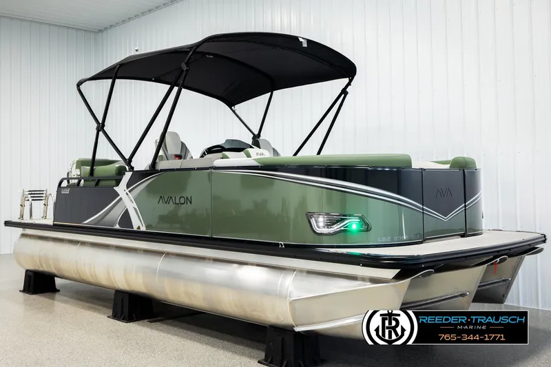 Slide: The Image of 2026 Avalon LSZ QLS pontoon boat with canopy in showroom setting. - 2