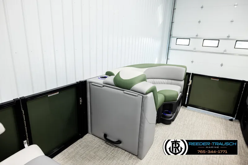 Slide: The Image of 2026 Avalon LSZ QLS pontoon boat interior with green and gray seating, cup holders, and marine branding. - 23