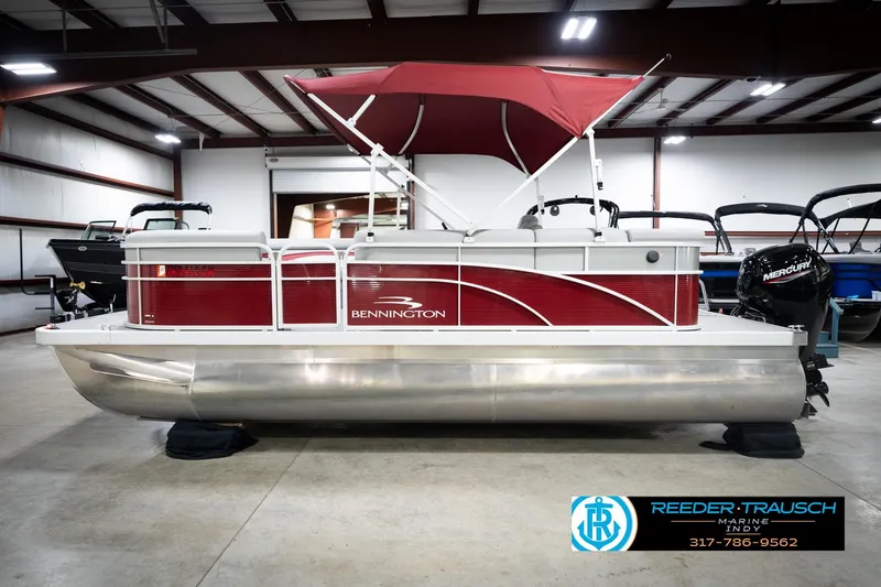 Slide: The Image of 2023 Bennington 20 SV pontoon boat with red canopy in showroom. - 11