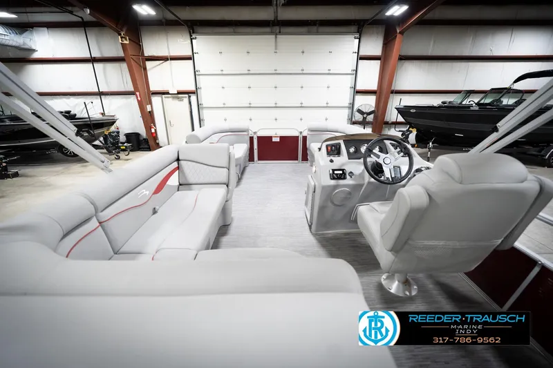 Slide: The Image of 2023 Bennington 20 SV pontoon boat interior in showroom with plush seating and steering console. - 19