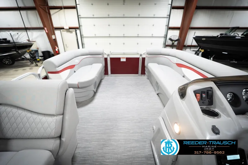 Slide: The Image of 2023 Bennington 20 SV pontoon boat interior with plush seating in a showroom. - 20
