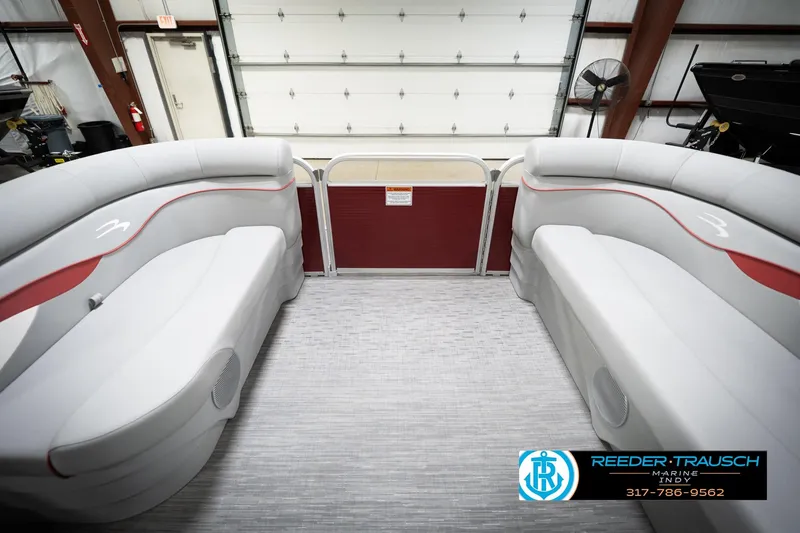 Slide: The Image of 2023 Bennington 20 SV pontoon boat interior with gray seating and red accents in a showroom. - 21