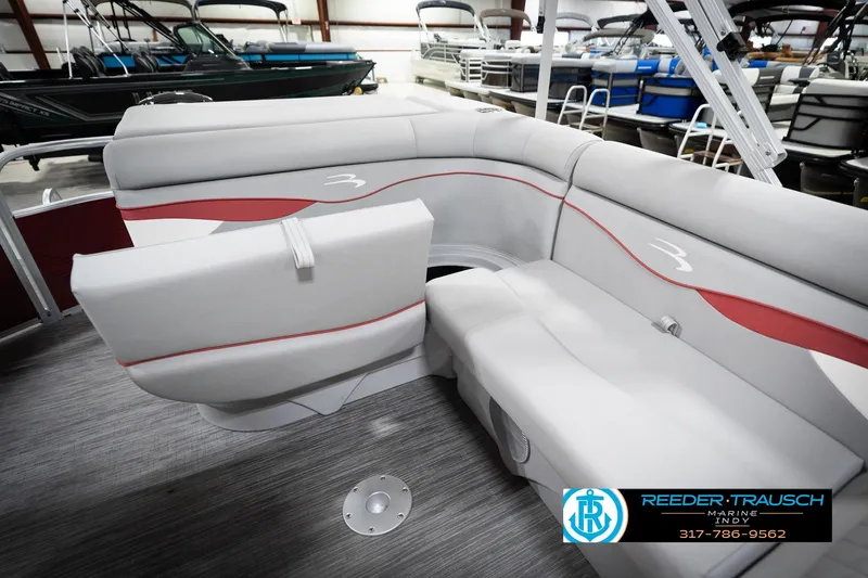 Slide: The Image of 2023 Bennington 20 SV pontoon boat interior with gray and red seating in showroom. - 30