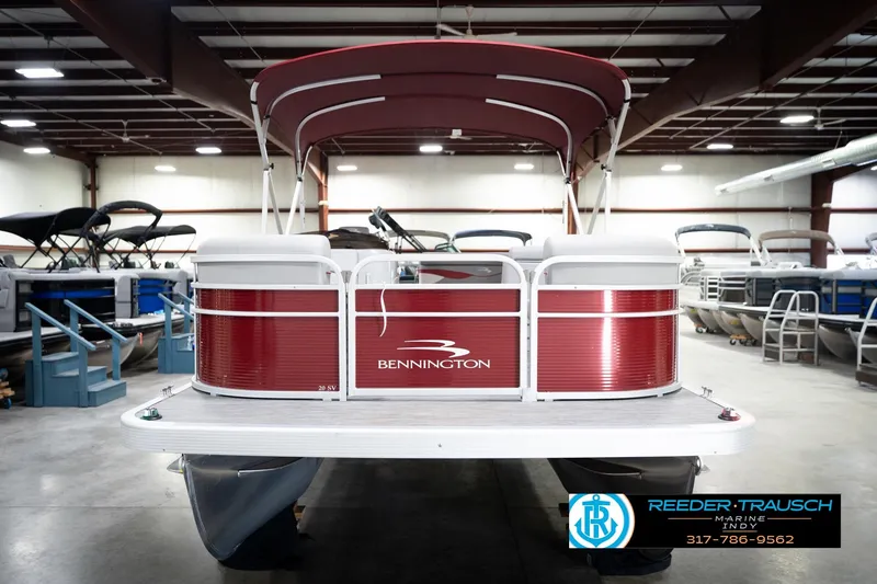 Slide: The Image of 2023 Bennington 20 SV pontoon boat in showroom, featuring red exterior and canopy. - 5